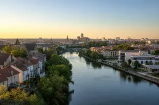 Panorama of Longeville-lès-Metz and Metz skyline with the Moselle river and regional French architecture under morning sunlight.